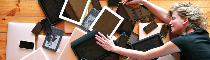 Vrouw ligt op tafel met meerdere tablets en smartphones