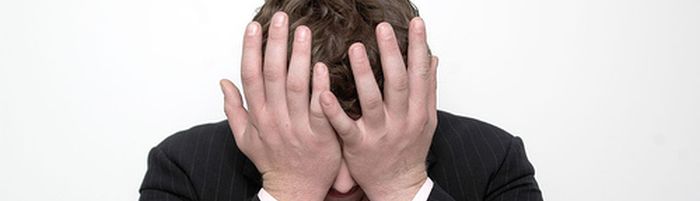 Man met hoofd in handen na zure excuses