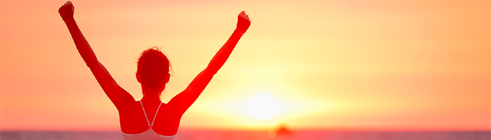 Vrouw juichend bij ondergaande zon illustreert een succesvol CRM selectietrajact