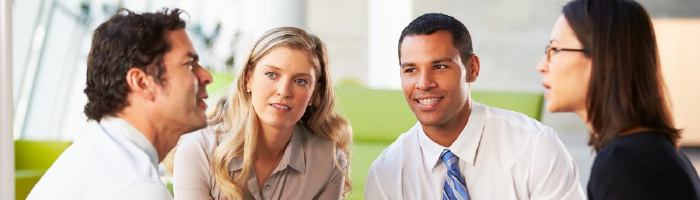 vier personen in overleg over CRM implementatie