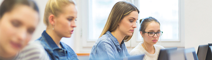 Personen aan het werk op computers met een infographic over het onderwijs