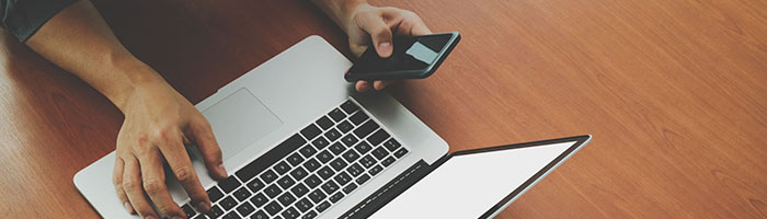 Persoon bezig met laptop en telefoon weerspiegelt omnichannel